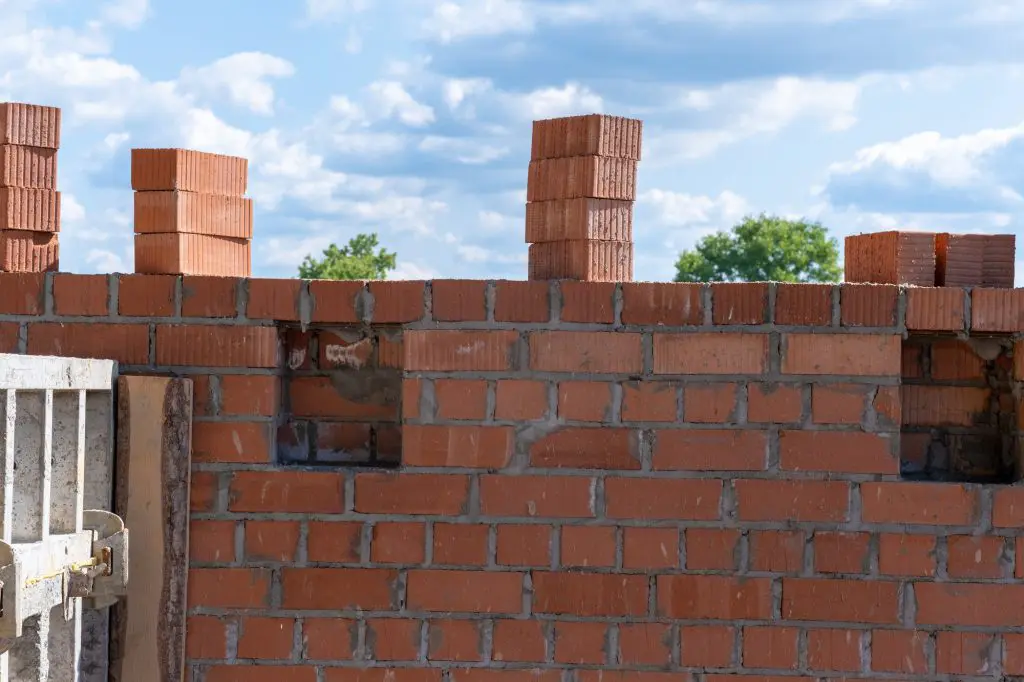 Unfinished brick wall of the house. Brickwork. Construction of a brick wall.